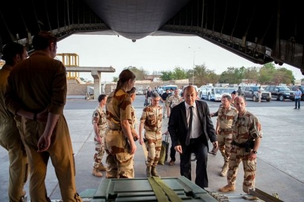 Le ministre français de la Défense Jean-Yves Le Drian (en costume), monte à bord d'un avion lors de sa visite au Mali, le 26 avril 2013 © AFP