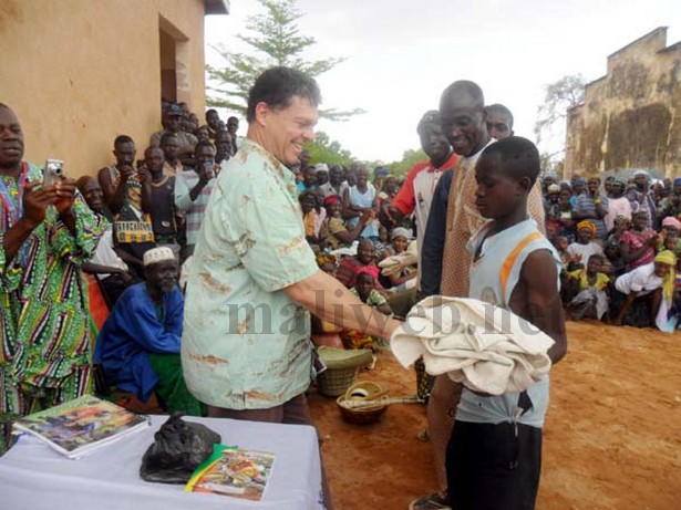 Thomas MCorrmark recevvant un souvenir offert par les villageois en guise de reconnaissance