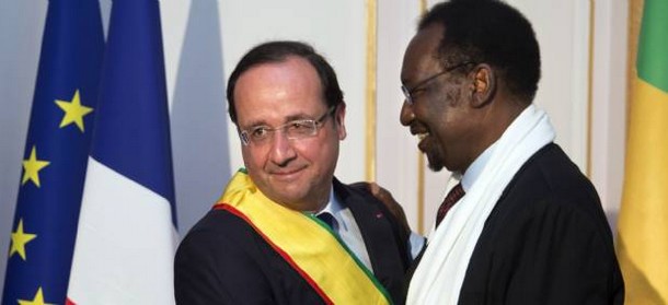 François Hollande, vêtu de l'écharpe du Mali, enlace le président malien de transition Dioncounda Traoré, à l'ambassade du Mali à Paris. © IAN LANGSDON / AFP