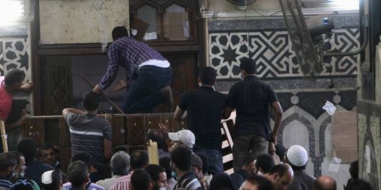 Des partisans de Mohamed Morsi barricadent les portes de la mosquée, tandis que des tirs sont échangés à l'extérieur entre des policiers et au moins un tireur posté sur le minaret. | REUTERS