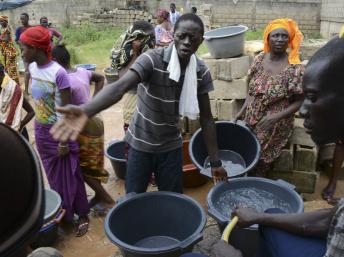 Des gens font la queue avec des seaux pour prendre un peu d'eau d'une source communale à Dakar, le 27 septembre 2013. REUTERS/