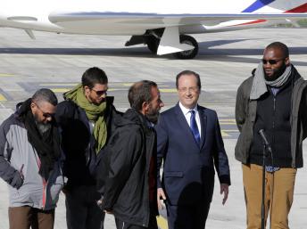 François Hollande, le président français (2nd d) avec les quatre ex-otages français, (de g à d) Marc Feret, Pierre Legrand, Daniel Larribe, Thierry Dol à leur arrivée sur le tarmac de l'aéroport militaire de Villacoublay, le 30 octobre 2013. Reuters