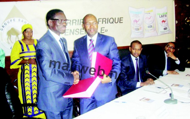 Christian Adovelande et le PDG Houd Baby échangeant les documents sous les regards des ministres Boubou Cissé et Ben Barka