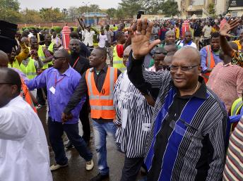 Roch Marc Christian Kaboré (d.), ancien président de l'Assemblée nationale burkinabè, salue la foule à son arrivée dans le cortège de l'opposition, le 18 janvier 2014 à Ouagadougou. AFP