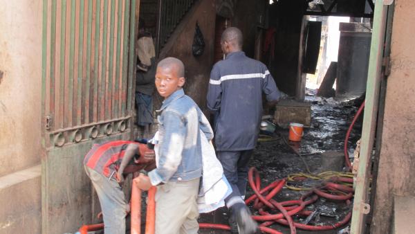 Des enfants du quartier aident les pompiers à éteindre les dernières flammes