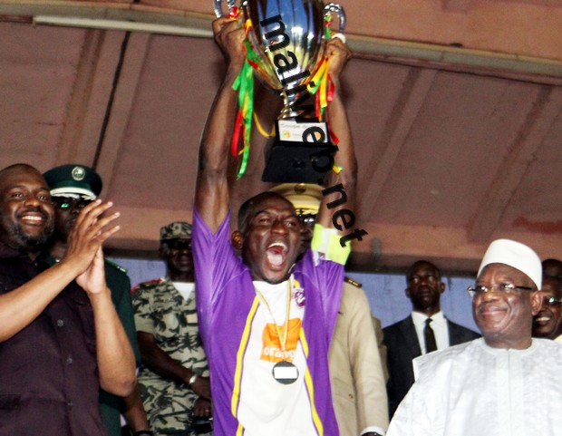 Le capitaine des Onze créateurs brandissant le trophée de la  coupe du Mali