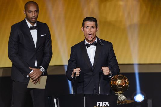 Le vainqueur du Ballon d'or 2014, sous le regard de Thierry Henry. | AFP/FABRICE COFFRINI