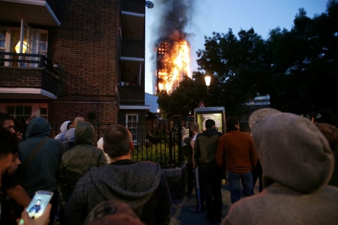 Des résidents regarde le gigantesque incendie qui ravage une tour d'habitation, le 14 juin 2017 à Londres / © AFP / Daniel LEAL-OLIVAS
