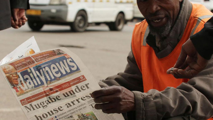 Un vendeur de rue lisant son journal, à Harare, le 16 novembre 2017. © REUTERS/Philimon Bulawayo
