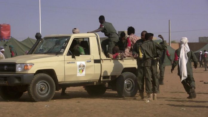 Des soldats se rassemblent près d'un pick-up après l'attaque kamikaze qui a ensanglanté un camp de Gao, au Mali, le 18 janvier 2017.