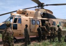 Des soldats maliens embarquent dans un hélico de l'armée de l'air du Mali