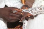 Un homme passant la bague au doigt de son épouse devant le maire
